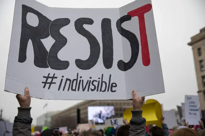 Protester holding sign that says Resist