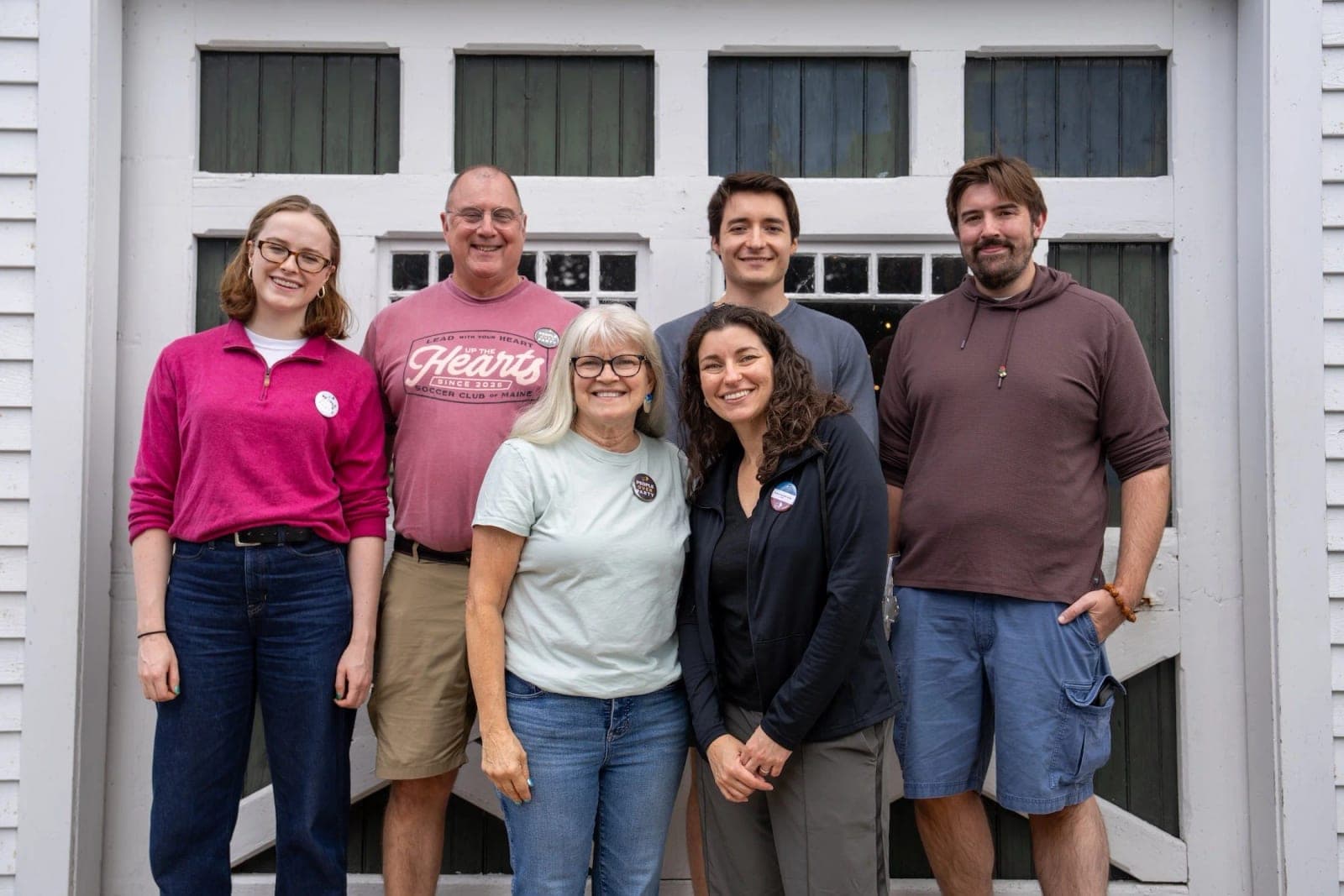 Six People Powered Maine volunteers stand together outside a white building.