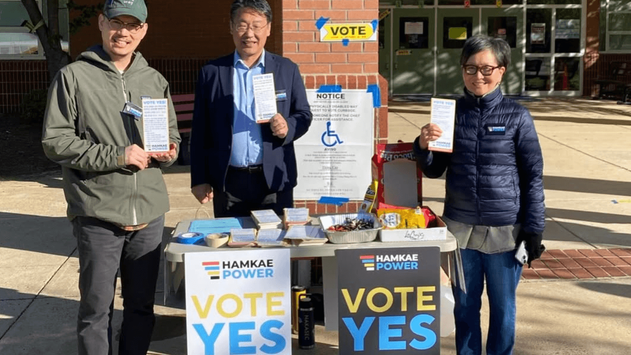 Hamkae Power volunteers staff a Vote Yes table outside a polling place.