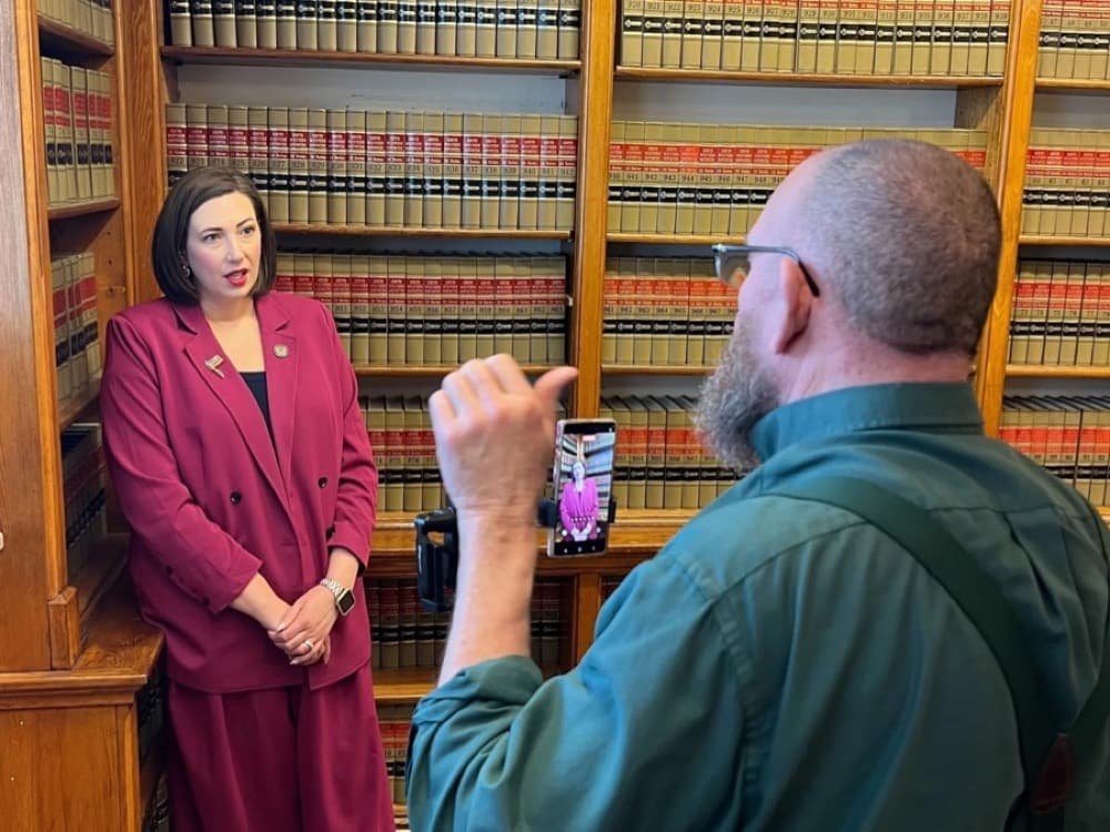 A creator films an interview in a law library.