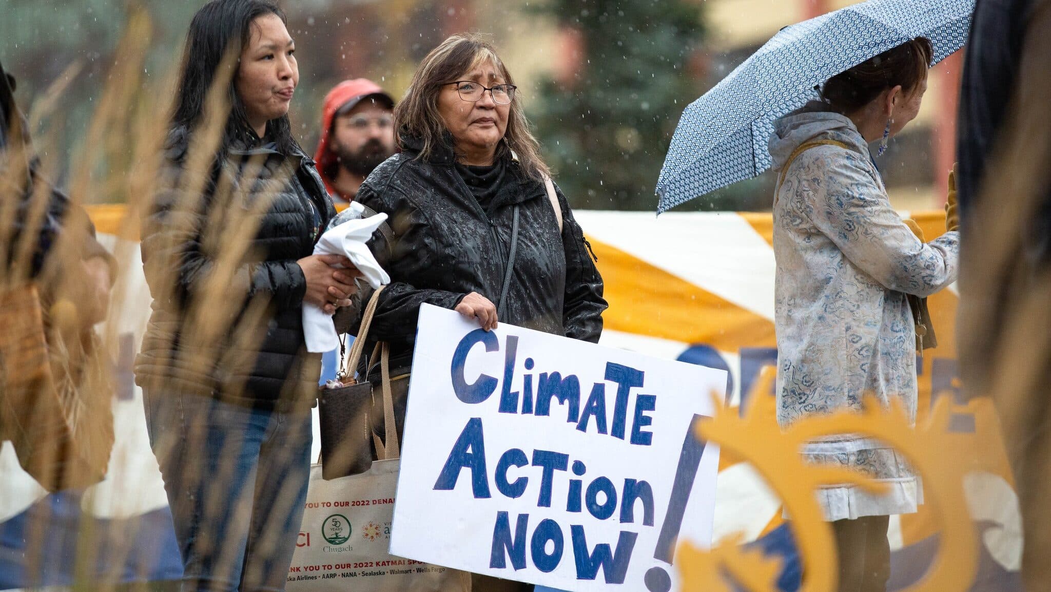 Alaska Center supporters hold a “Climate action now” sign.