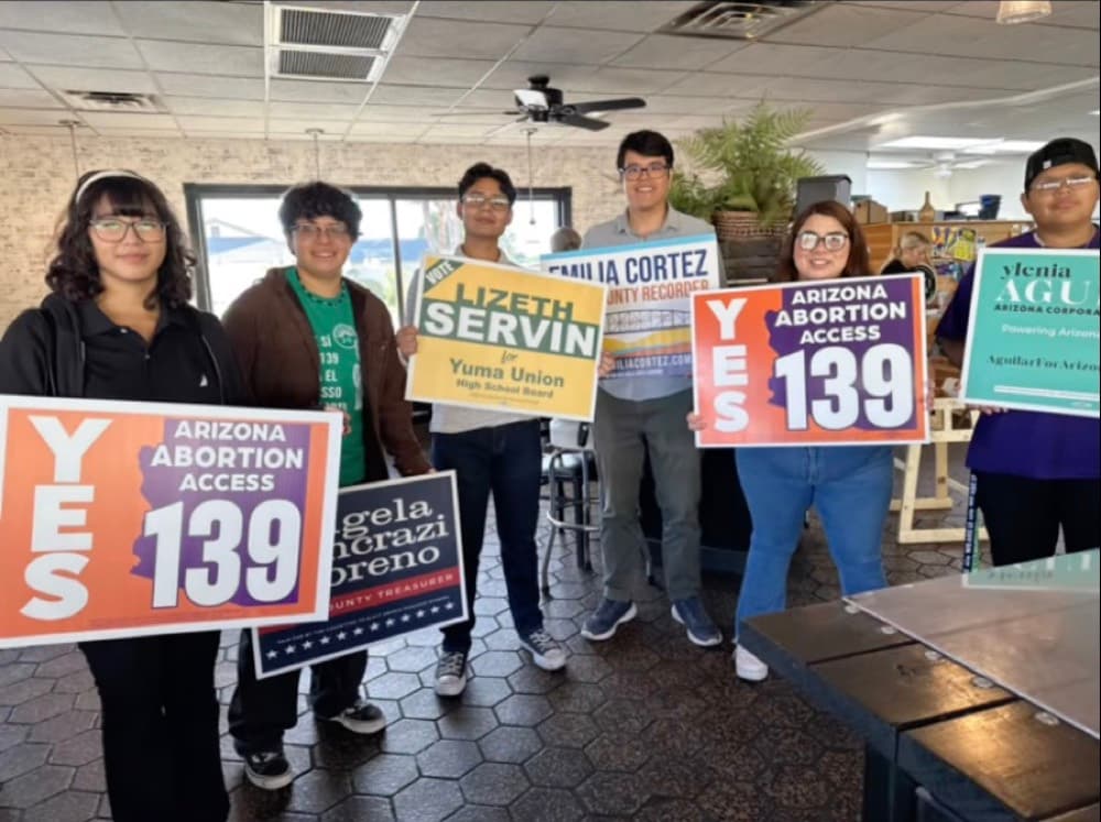 Arizona List volunteers hold Yes on 139 and candidate signs at a get-out-the-vote event.