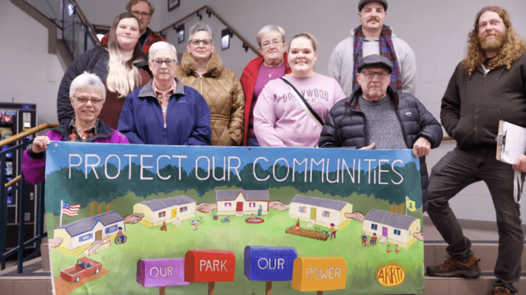 Maine Labor Climate Council members and mobile home residents pose behind a “Protect our communities” banner.