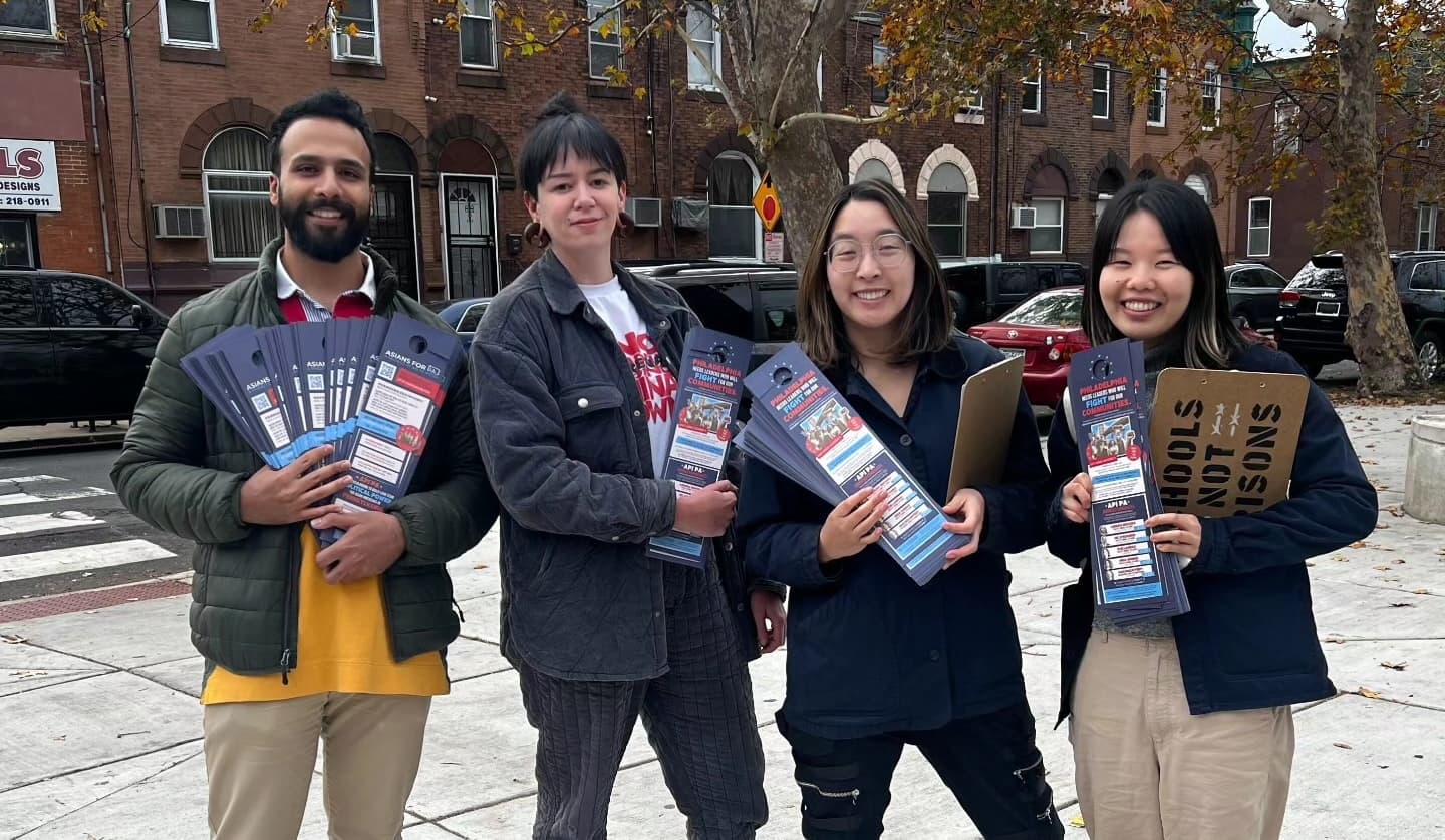Four API PA canvassers in Philadelphia hold voter guides and smile at the camera.