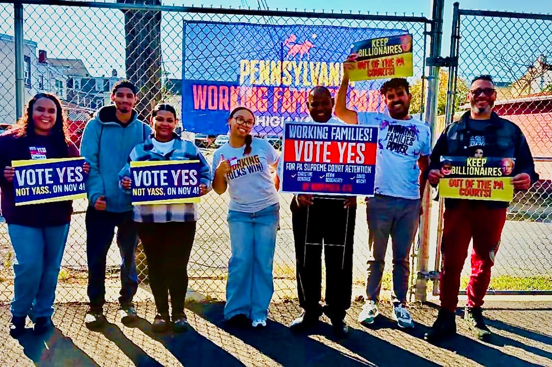 Pennsylvania Working Families Party volunteers hold “Vote Yes” signs for the state Supreme Court retention election.